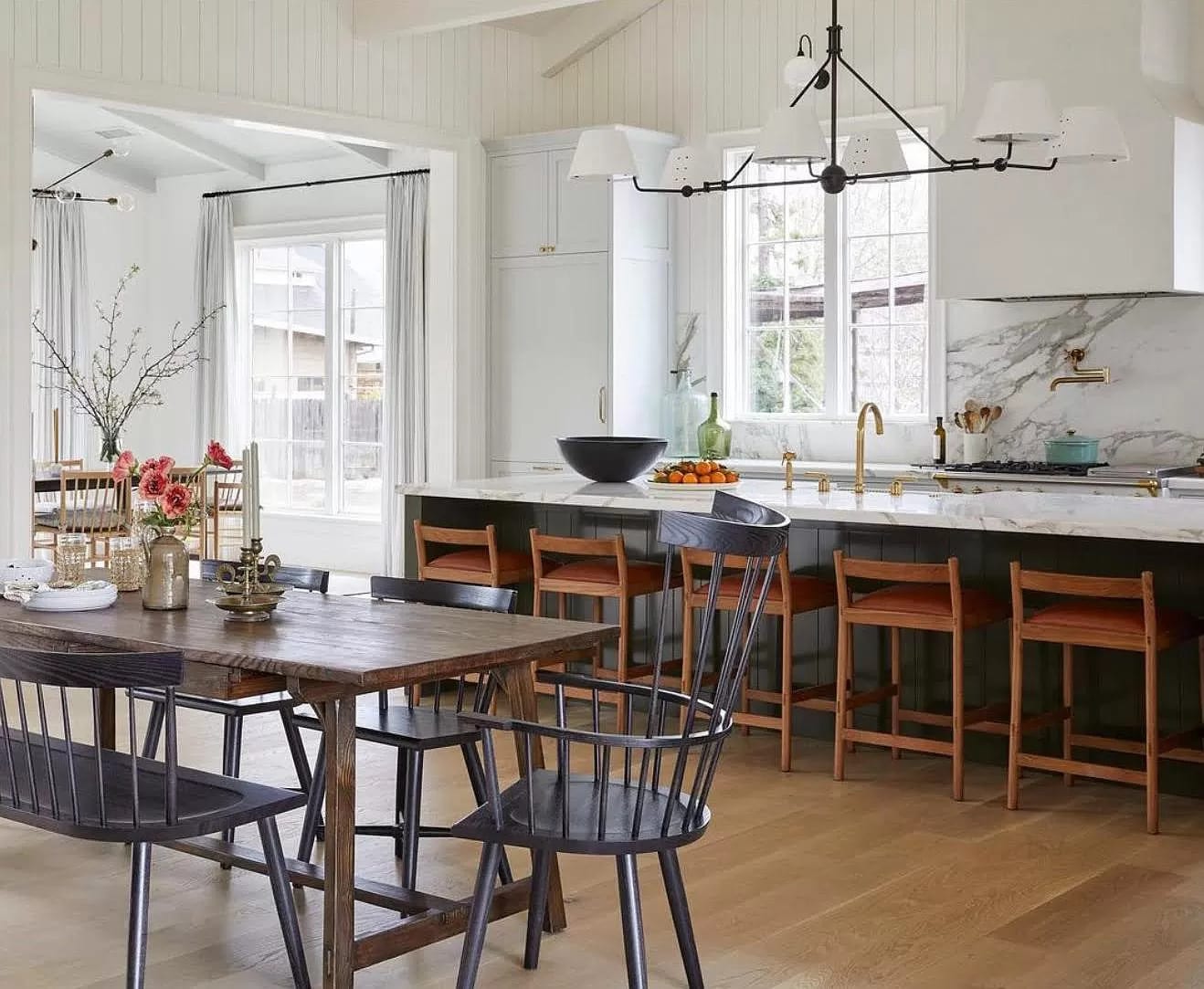 Warm white kitchen with wood island and farmhouse table