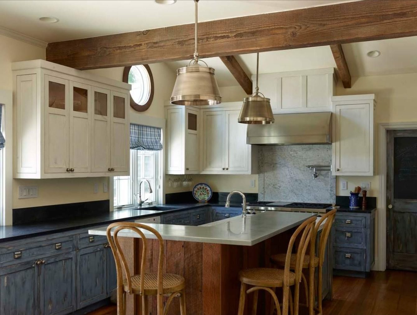 Refinished white kitchen cabinets under wood beams